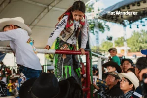 A young girls climbing on fence of a Rodeo Event